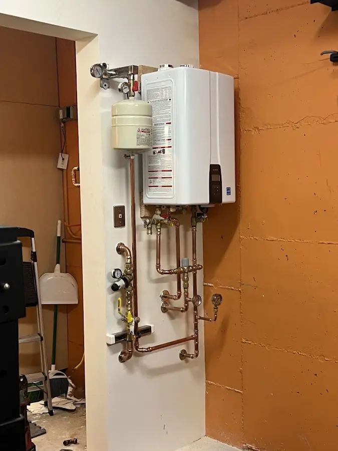 Plumbing technician inspecting water heater connections in Rock Island